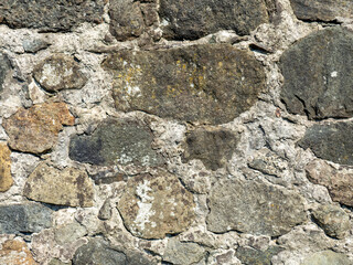 Remains of an old castle. Ancient fortifications made of stone. Museum in the open air. Wall of a medieval castle. Background from ancient stonework.