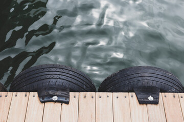 Wooden pier and old tires on the lake