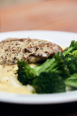 Chicken dish with cream and broccoli served in a white plate. Italian fine dinning