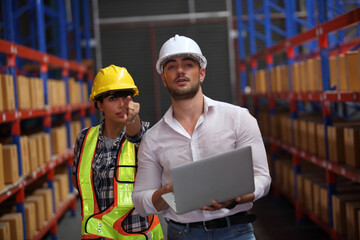 worker in warehouse,  using bar code scanner to scanning box and analyze newly arrived goods.  Working at warehouse.International export business concept