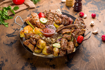 platter of different kebabs, kebab of pork, lula kebab, rack of lamb,chicken kebab,kebab of veal, grilled vegetables on plate saj on wooden table