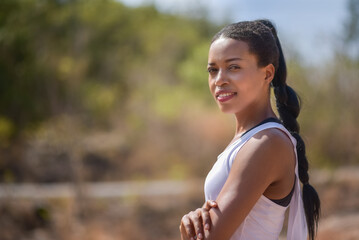 Portrait of Confident Attractive Sporty African American Woman with arms crossed standing on nature background at outdoor, Looking camera