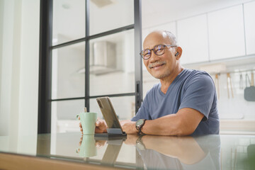 Portrait of Happy Smiling Senior mature male sitting using smartphone looking at camera at home, Leisure, Active Lifestyle