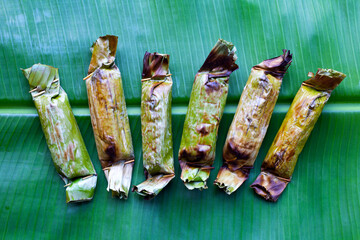 Grilled sticky rice in banana leaves with banana filling