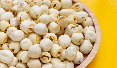 Dried lotus seeds on yellow background.