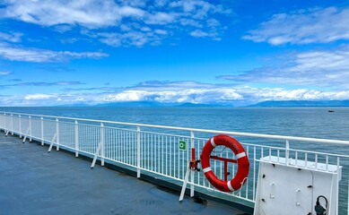 the deck of the ship is visible Only the white bridge and the red rescue circle as well as the sky...