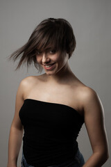 Naklejka premium Beautiful girl upper body portrait. Smiling with wavy hair on face. .