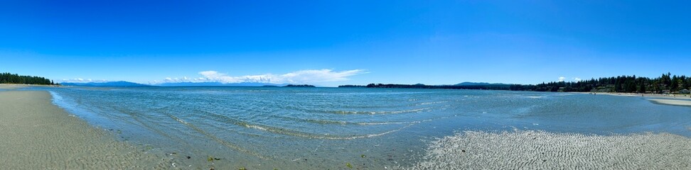 the coast of the Pacific Ocean on Vancouver Island, it can be seen that there was a low tide and now the calm of the wave is barely splashing on the amulet calm silence Rathtrevor Beach, Parksville.