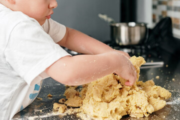 Unrecognizable boy kneading dough for arepas