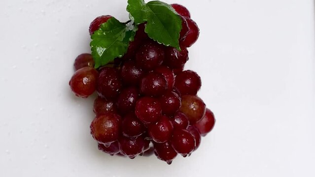 Animated red grapes with water drops green grape leaves white background video