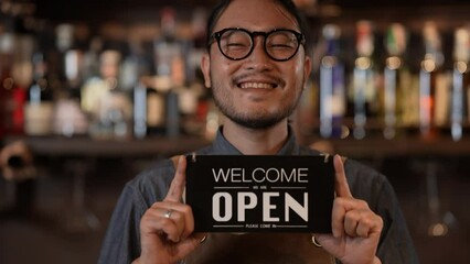 Night club concept of 4k Resolution. Asian man holding a sign welcoming customers in a shop. A group of specialized clubs that sell alcoholic beverages.