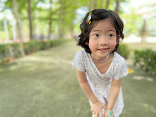 cute little girl smile with beautiful pose in the garden with copy space