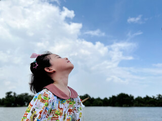 cute little girl looks into the bright day sky for new opportunities