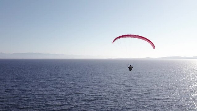 Paragliders beside the ocean, beautiful sunny day, aerial drone footage, soaring, coastline. 4K 24FPS