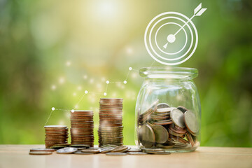 Stacking coins in a jar with grow up on wooden , nature background for financial investment and interes . Saving money for wealth, pension retirement and growth of business income concept.