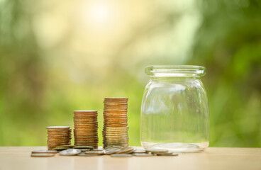 Stacking coins in a jar on wooden , nature background for financial investment and interes . Saving money for wealth, pension retirement and growth of business income concept.