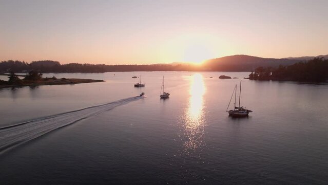 Aerial drone footage boats in harbour at sunset, Sooke BC, sail boats, marina, sunset sky. 5.4K TO 4K 24FPS.