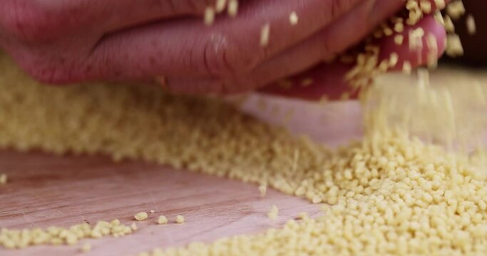 Move your hands cereal porridge couscous from wheat or millet, cooking dishes from traditional cereals crushed yellow couscous