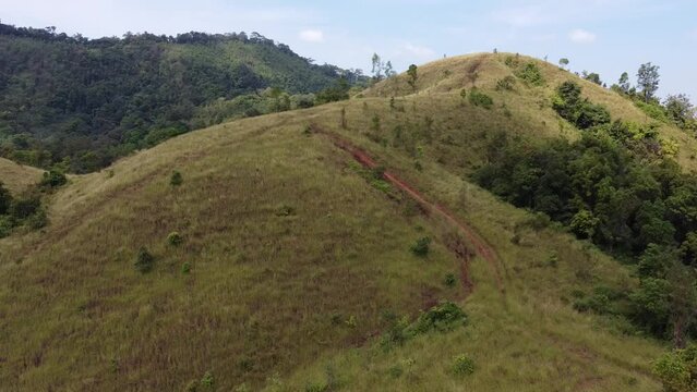 4K over bald mountain or Phu Khao Ya with green grass field and blue sky. One of natural travel attraction in Ranong province, Thailand
