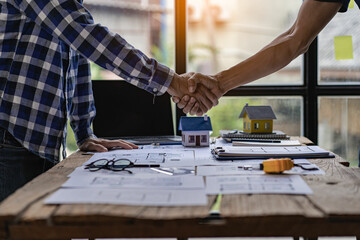 Engineers and construction supervisors shake hands after a consultation meeting to begin planning a new contract in the construction site office. team work concept working together and contractor