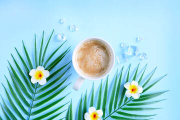 Milk coffee with plumeria flowers and palm leaves on blue. Cozy vocational morning. Coffee break. Relaxing atmosphere. Eco life. Summer style. Hotel room service. Exotic countries.