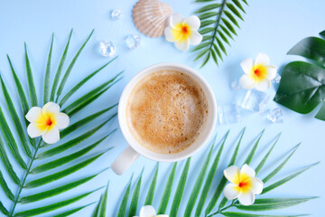 Milk coffee with plumeria flowers and palm leaves on blue. Cozy vocational morning. Coffee break....