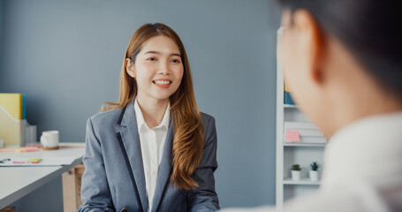 Young Asia businesswomen applicant pass job interview for enterprise company position or during corporate business meeting sitting on office desk at workplace. Hire candidate at job interview concept.