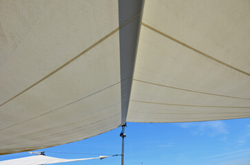 parasol, awning, folding tarpaulin against the sun is rolled up into a roll hanging in space above...