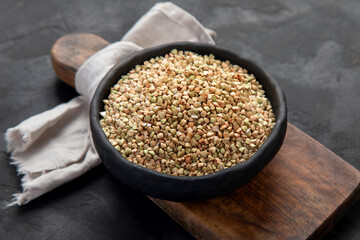 Raw green buckwheat on dark background. Food ingredients.