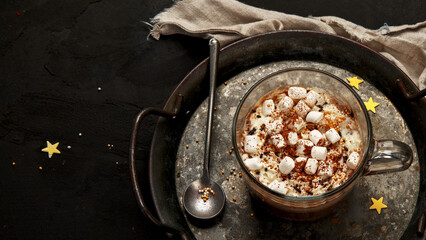 Cacao with marshmallow and cacao powder in mug.