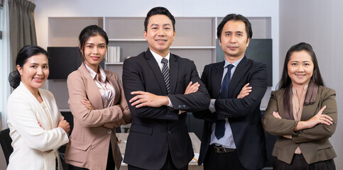 Group of Asian Business people wearing formal suit dress, standing and have positive, fighting hand gesture with confident inside of meeting room office area. Teamwork, success employee banner shot.