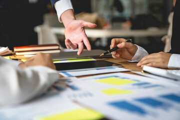 Financial teamwork with Marketing and Accounting Business professionals working together at office desk, hands close up pointing out financial data on a report negotiation, Analysis, Discussion