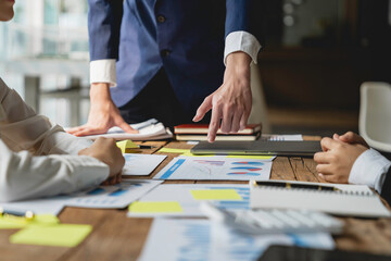 Financial teamwork with Marketing and Accounting Business professionals working together at office desk, hands close up pointing out financial data on a report negotiation, Analysis, Discussion