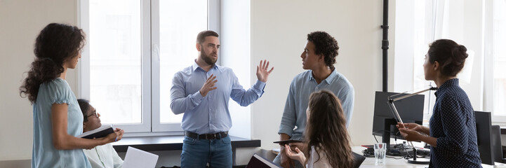 Panoramic image diverse employees take part in group meeting in modern co-working office. Multi...