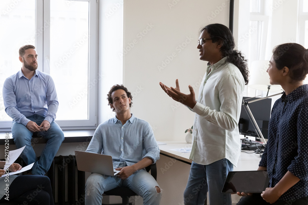 Canvas Prints Diverse employees listen to Indian company boss or project leader, gathered together for searching solutions, share ideas, brainstorming participate in group meeting in office. Cooperation concept