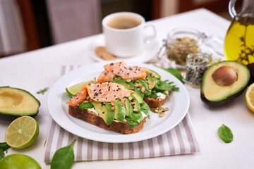 Freshly made Avocado, salmon and cream cheese toasts on a white ceramic plate