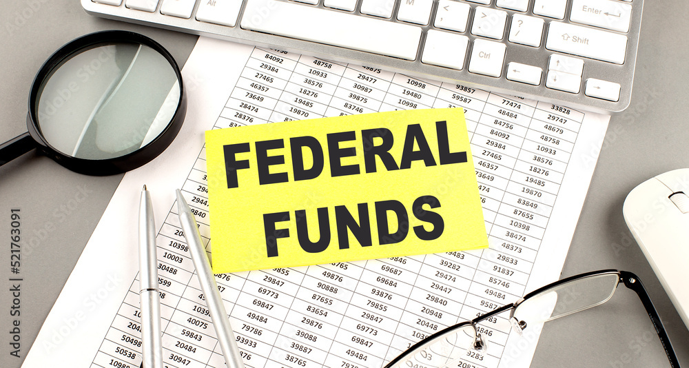 Poster federal funds text written on a sticky on chart with keyboard and magnifier