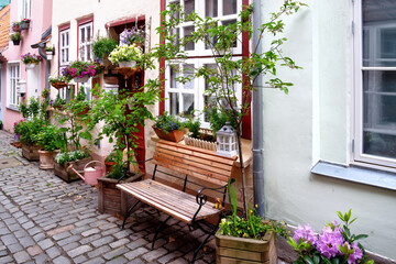 Fototapeta na wymiar Idyllic sitting place surrounded by flowers in front of a house in Lübeck, Germany