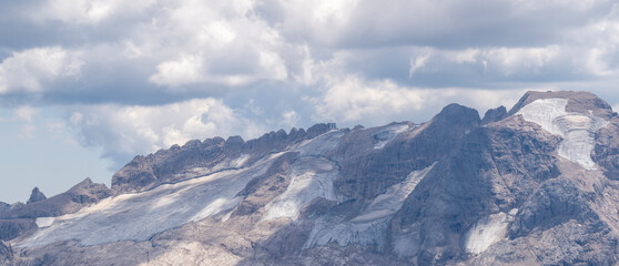 Amazing landscape to the Marmolada and its glaciers during summer time. Melting of glaciers due to global warming. It is the highest mountain of the Dolomites. Italian alps. Summer 2022