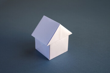 White paper house origami isolated on a grey background