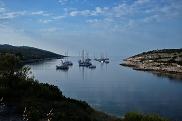 Deep bay in Adriatic sea with sailboats against clear blue sea