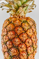 Fototapeta premium Ripe pineapple close-up on a white background with copy Ripe tropical juicy fruit. Delivery prospectus or flyer idea, vertical frame