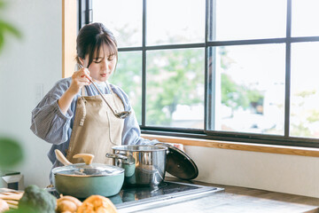 キッチンで料理するアジア人女性（失敗・疲労）
