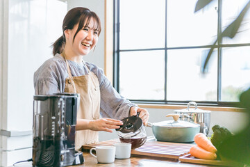 キッチンでコーヒーをいれる女性
