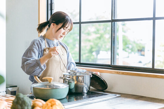 キッチンで料理するアジア人女性（失敗・疲労）
