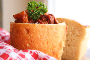 Traditional South African cuisine. Bunny chow. Curry filled loaf of bread. Chicken curry 