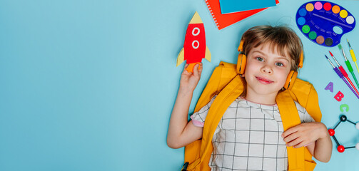 Cute girl surrounded by different school stationery