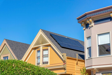 View of solar panels on a gable roof of a yellow house in San Francisco, California