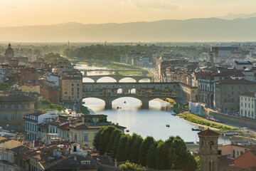 Fototapeta na wymiar Goldsmiths Old Bridge ('Ponte Vecchio') and other bridges over the River Arno at summet sunset with haze on the horizon , Florence- Firenze, Tuscany, Italy
