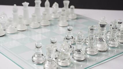 Transparent chess figures on reflective chess board. Pawns forward one step. Chess board game